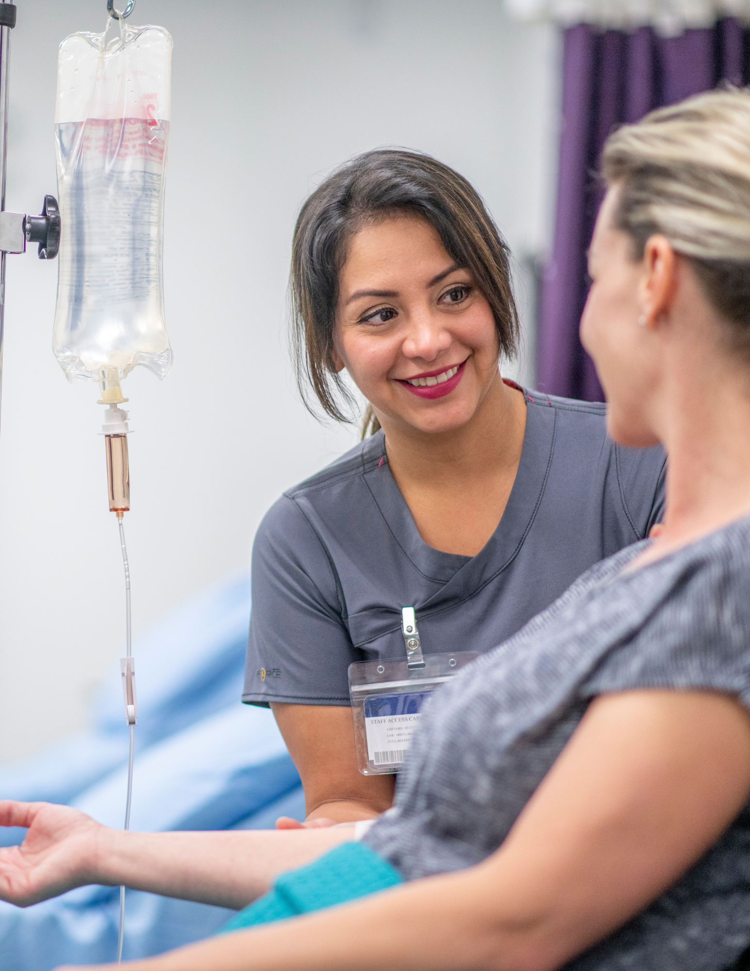 Doctor consulting patient receiving an  IV treatment